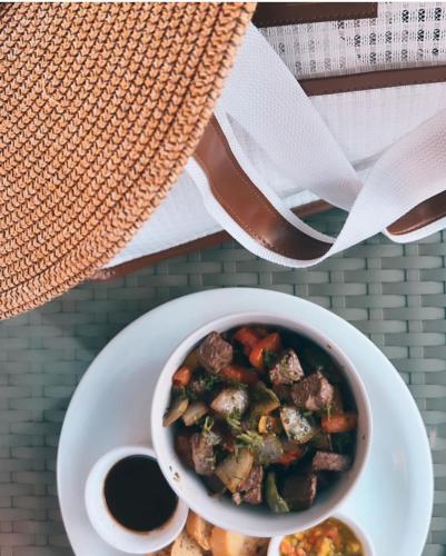 a bowl of food on a table with a plate of food at Rafain Palace Hotel & Convention Center in Foz do Iguaçu