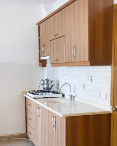 a kitchen with wooden cabinets and a sink at KAJU ROOMS Bozburun in Bozburun