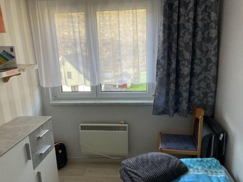 a small room with a window and a bed and a chair at Secluded Holiday Home in Lichtenau with Private Garden in Langenbach