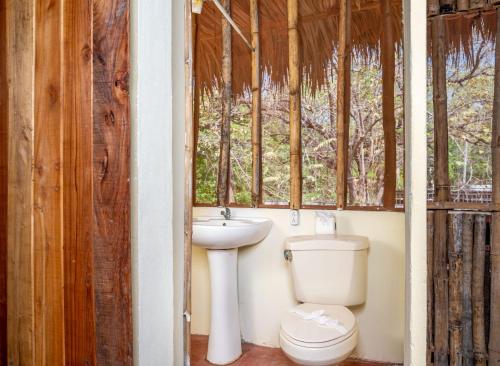 La salle de bains est pourvue de toilettes, d'un lavabo et d'une fenêtre. dans l'établissement Tylers Place Home, à Coco
