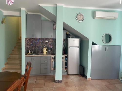 a kitchen with blue walls and a kitchen with a refrigerator at Apartman green home (pool) in Radovići
