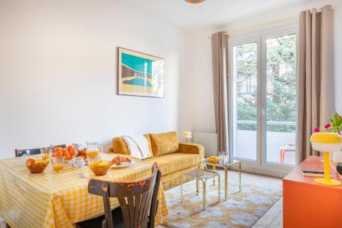 un salon avec une table et un canapé dans l'établissement Petit jaune, T2 centre ville Marseille avec balcon, à Marseille