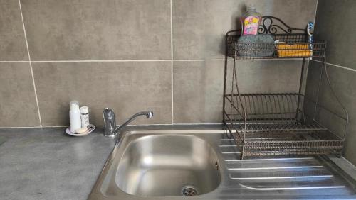 a kitchen sink with a faucet and a shelf at La p'tite maison 