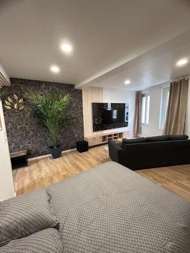 un salon avec un canapé et une télévision à écran plat dans l'établissement Appartement tout confort, à Harfleur