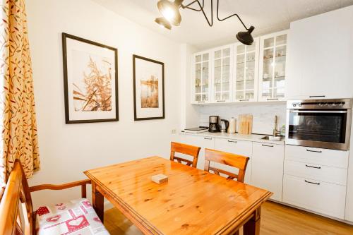 eine Küche mit einem Holztisch und eine Küche mit weißen Schränken in der Unterkunft NickHaus in Cochem