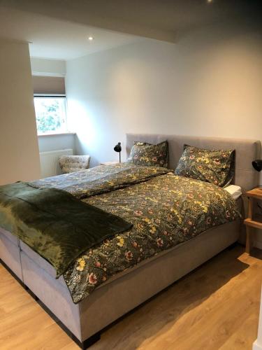a bedroom with a bed with a blanket on it at Hollema Logies - De Pastorie in Earnewâld