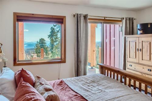 - une chambre avec un lit et une grande fenêtre dans l'établissement Perfection South by Okanagan Premier, à Big White