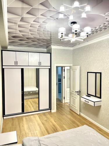 a bedroom with a bed and a room with a ceiling at Residential Complex «Yunusabad - Khon Saroy» in Tashkent
