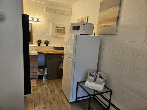 a kitchen with a refrigerator with a microwave on top of it at Rolling Hills Motel in Wantage