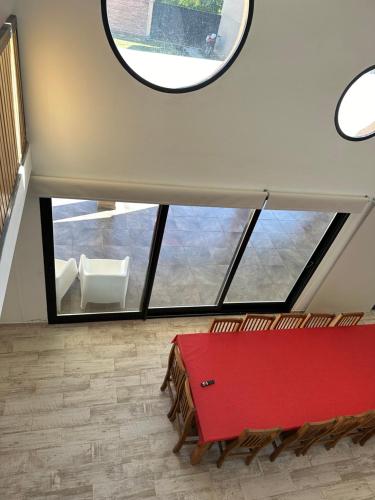 um quarto com uma mesa vermelha e uma grande janela em Quincho Melincue em Melincué