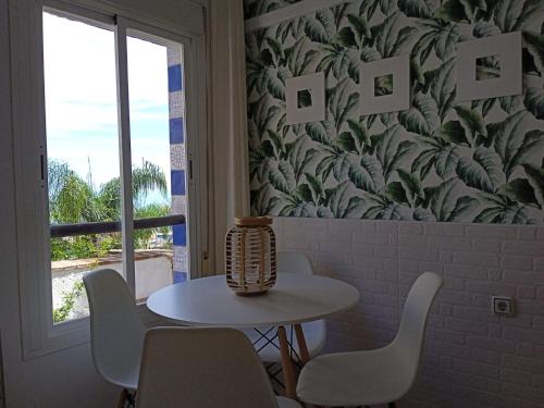 einen Tisch mit Stühlen und eine Vase darüber in der Unterkunft Apartamento Pepa Bajondillo in Torremolinos