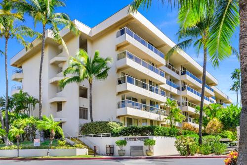a building with palm trees in front of it at Maui Banyan Vacation Club in Wailea