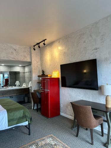 a hotel room with a red refrigerator and a kitchen at Neon Cowboy Roadhouse at Hunters Hot Springs in Lakeview