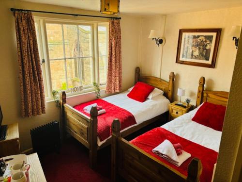 1 dormitorio con 2 camas y ventana en FARRIERS ARMS, en Worcester