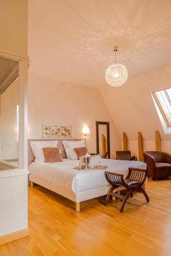 une chambre avec un grand lit blanc et une table dans l'établissement Demeures & Châteaux Auberge de la Tour - Hôtel & Restaurants - Marcolès Auvergne, à Marcolès