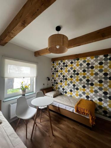 a bedroom with a bed and a table and chairs at Vintage Villa B&B in Jastrzębia Góra