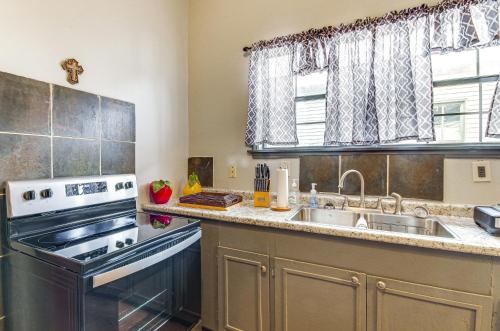 a kitchen with a sink and a stove at Cozy Vicksburg Home with Patio about 1 Mi to Riverfront! in Vicksburg
