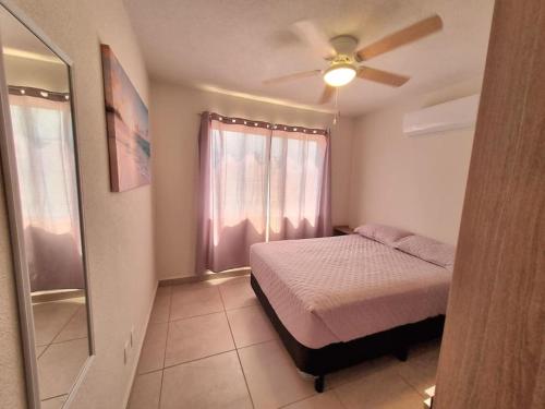 a bedroom with a bed and a ceiling fan at Increíble Departamento Diamante in Acapulco