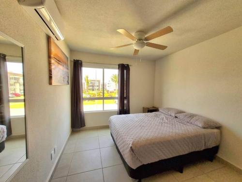 a bedroom with a bed and a ceiling fan at Increíble Departamento Diamante in Acapulco