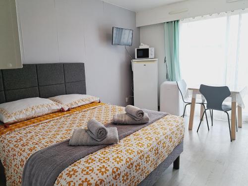 een slaapkamer met een bed met handdoeken erop bij Studio Moderne - Plage du Grazel in Gruissan