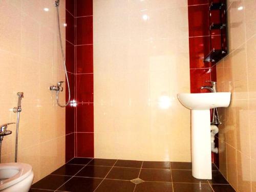 La salle de bains est pourvue de toilettes et d'un lavabo. dans l'établissement Guliyev Home, à Qax