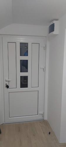 a room with a white cabinet with two windows at Apartmani Doksas Degurić in Belić