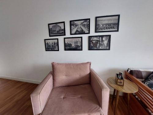 a living room with a couch and pictures on the wall at Book Santos - Unlimited 1709 - Apartamento Vista Mar in Santos