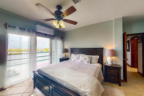 um quarto com uma cama e uma ventoinha de tecto em Suite B301 at Mara Laguna em San Pedro
