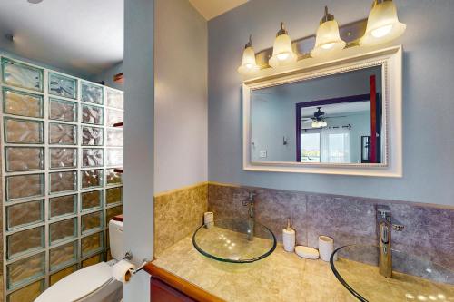 uma casa de banho com um lavatório de vidro e um espelho. em Suite B301 at Mara Laguna em San Pedro