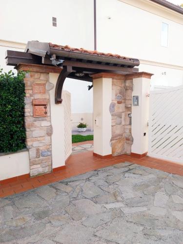 an entrance to a white house with a stone wall at BEE HOME in Luni