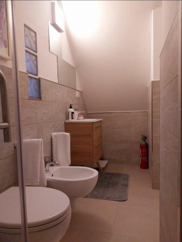 a bathroom with a white toilet and a sink at BEE HOME in Luni