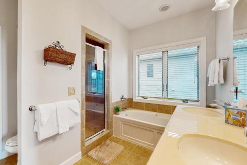 a white bathroom with a tub and a sink at The Owl's Nest at the Reserve in Sugar Mountain
