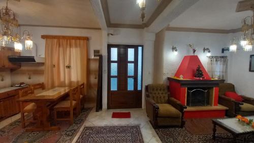 a living room with a red fireplace and a table at ΑΡΜΟΝΙΑ MountHome awesome stay in Arachova