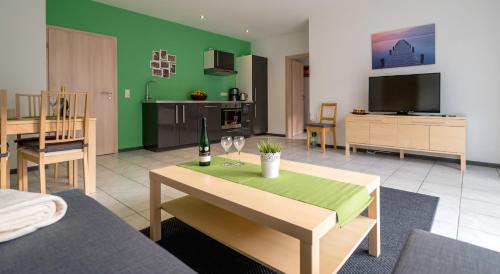 a living room with a table and a green wall at Moseltraum in Bruttig-Fankel