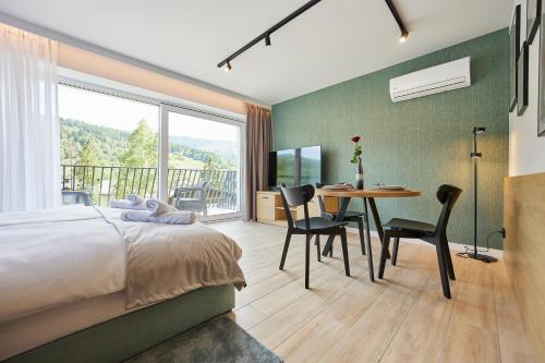 a bedroom with a bed and a table with chairs at EveRest Apartamenty Szczyrk in Szczyrk