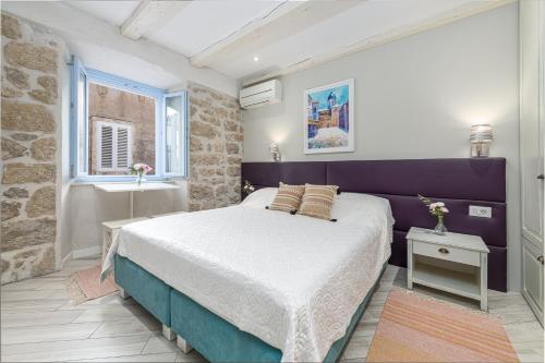 1 dormitorio con cama, ventana y lavamanos en Villa Amoroza Cavtat, en Cavtat