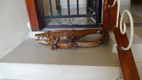 a snake statue sitting on the floor next to a window at Londoninnn in Bijilo