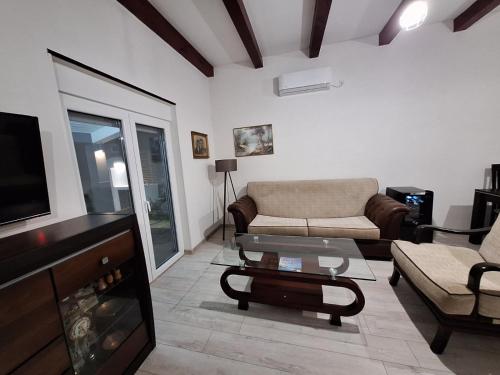 ein Wohnzimmer mit einem Sofa und einem TV in der Unterkunft Holiday home Bobija Skadar lake in Karuč