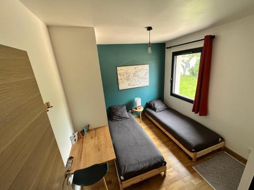 Habitación con 2 camas, mesa y ventana en Chambre privée au calme - Proche gare - Parking gratuit, en Le Gond