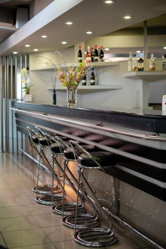 a row of stools at a bar in a restaurant at Hotel President in Timişoara