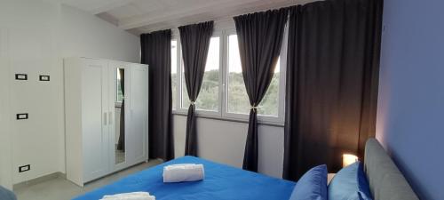 a bedroom with a blue bed and a window at I Coralli di Brucoli in Brucoli