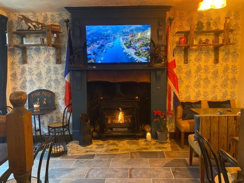 a living room with a fireplace with a tv on top at Moon River Bellac Chambre d'hotes in Bellac