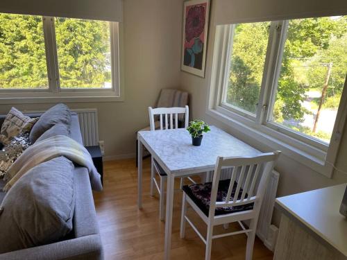 ein Wohnzimmer mit einem Sofa und einem Tisch mit Stühlen in der Unterkunft Litet modernt fristående hus i Skärgården på Värmdö, Stockholm in Värmdö