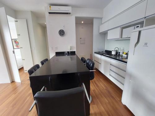 a kitchen with a large black table and chairs at Book Santos - Unlimited 1709 - Apartamento Vista Mar in Santos