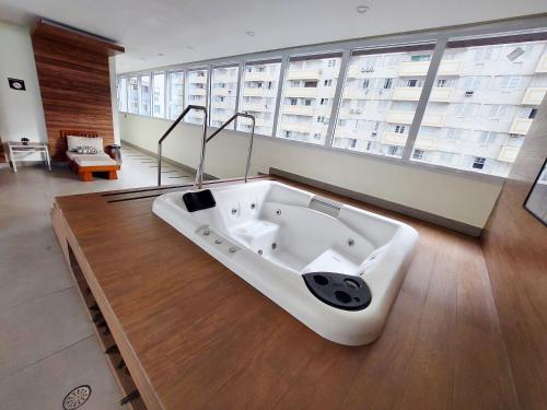 a bath tub in a room with a large window at Book Santos - Unlimited 1709 - Apartamento Vista Mar in Santos