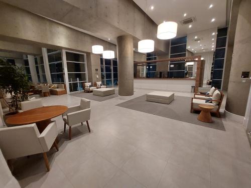 a lobby with a table and chairs in a building at Book Santos - Unlimited 1709 - Apartamento Vista Mar in Santos