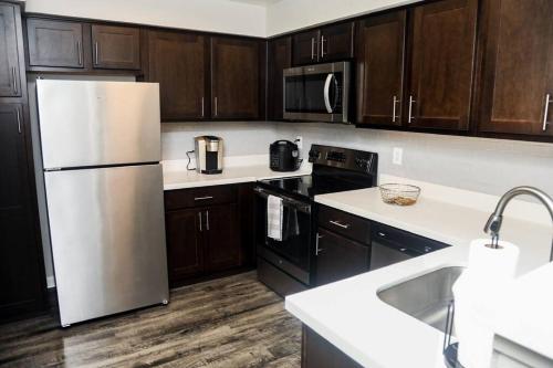 a kitchen with a white refrigerator and wooden cabinets at Apartment in Houston Med Center in Houston