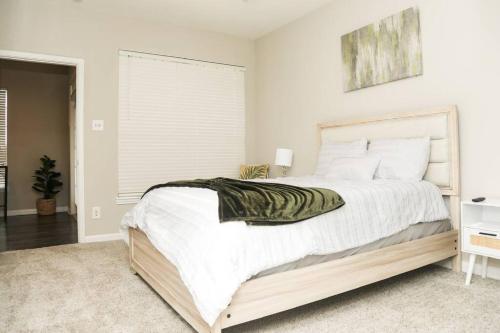 een slaapkamer met een groot bed met witte lakens bij Apartment in Houston Med Center in Houston