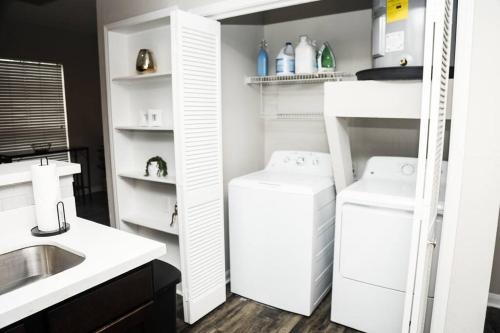 een witte keuken met een wastafel en een koelkast bij Apartment in Houston Med Center in Houston