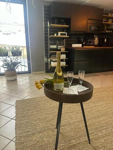 a table with a bottle of wine and two glasses at La stanza sul Porto in Pozzuoli